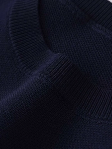 Detailed view of the ribbed neckline on this navy blue heart-hollow knit sweater