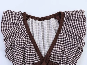 Close-up of the brown plaid V-neck collar with elastic band and pleated fabric texture