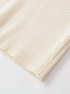 Close-up of the cream-white ribbed knit texture and premium elastic fabric detail