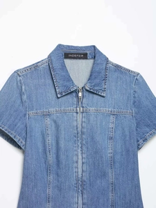 Detail of light blue washed denim shirt featuring metal zipper and classic collar
