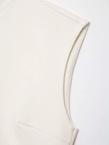 Detail of premium white hollowed sleeveless dress showing shoulder stitching and textured fabric