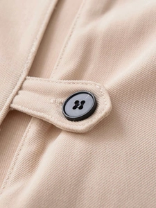 Macro detail of khaki pleated midi dress showing fabric texture and black matte button
