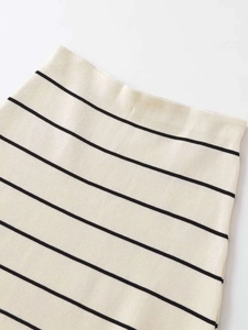 Dettaglio ravvicinato della vita elastica di una gonna in maglia a righe crema e nere