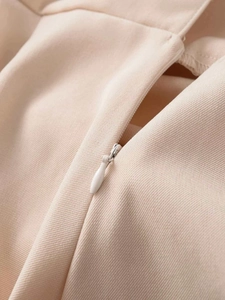 Detail of beige twill fabric featuring a matching invisible zipper and drop puller