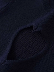 Close-up of navy blue knit sweater featuring heart-shaped cutout and fine stitch texture