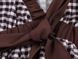 Detailed macro shot of vintage brown gingham waist tie and pleats on a sleeveless shirt
