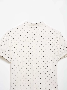 Detail of white ruffle trim blouse with black polka dots showing the collar and sleeve back