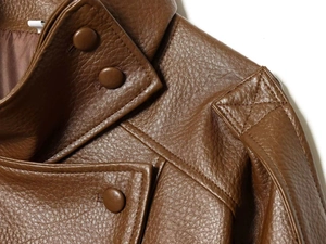 Detail of shoulder epaulettes and stitching on dark brown faux leather biker jacket