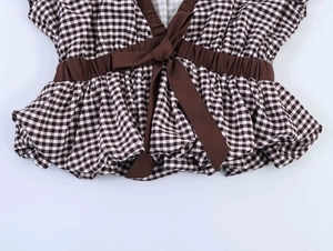 Detail of vintage brown plaid shirt featuring a waist tie and delicate bow knot