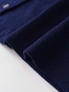 Dettaglio ravvicinato del tessuto in maglia blu scuro con trama fine e filato morbido