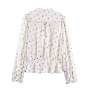 Floral long sleeve blouse with ruffled hem and back pleated details on white background
