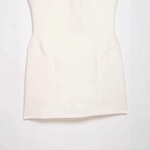 Minimalist white sleeveless dress featuring structural waist seams and A-line silhouette