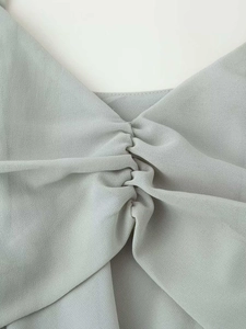 Dettaglio dello scollo a V con design arricciato su tessuto georgette grigio-azzurro