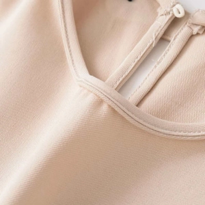 Detail of elegant beige midi dress neckline with teardrop button closure and twill texture