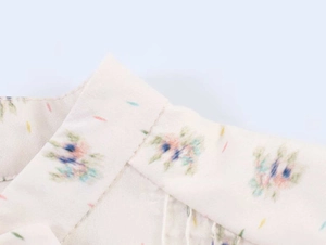 Detailed macro shot of a floral print women's blouse collar with fine stitching