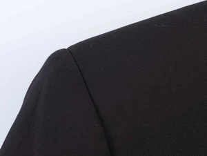 Detailed view of structured shoulder seams and black twill fabric texture on a suit jacket