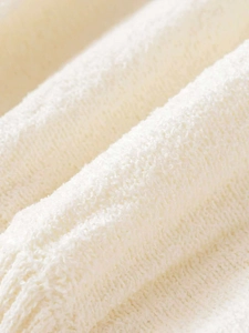 Close-up of white soft knit fabric texture showing high-quality wool-like yarn details
