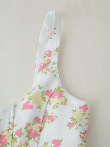 Detailed macro view of woven fabric texture and floral print on summer jumpsuit straps