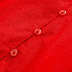 Macro detail of red flutter sleeve shirt with matching resin buttons and linen texture