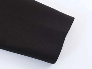 Close-up of premium black fabric texture on irregular hemline of the fashion blazer set
