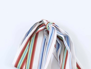 Detail shot of multicolor striped fabric accessory with central knot and vibrant vertical stripes