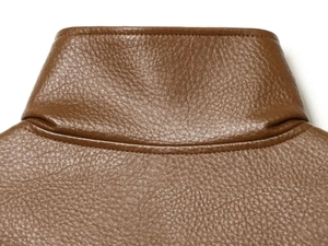 Close-up detail of brown faux leather jacket collar showing lychee grain and double stitching