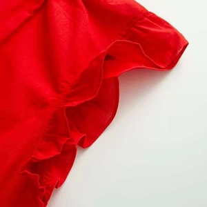 Detail of red summer shirt with ruffled flutter sleeves and soft cotton texture