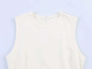 Detail shot of a beige sleeveless dress featuring a round neckline and back zipper closure