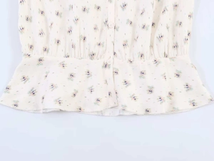 Detailed view of floral blouse featuring blue-purple flowers and button-down front