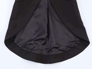 Detail of elegant black irregular swallowtail hem showing matte fabric and satin lining