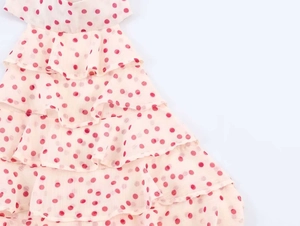 Detail of pink polka dot georgette fabric with tiered ruffle layers on a halter top
