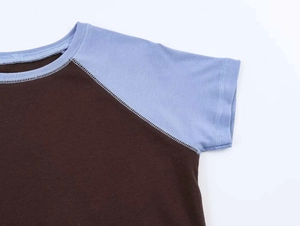 Close-up of contrast raglan sleeve seams and high-quality brown cotton knit fabric