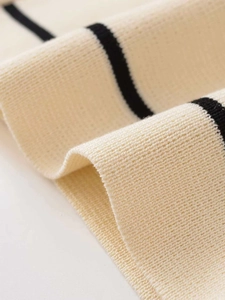 Vista macro di tessuto a maglia fitta con strisce nere e base bianco crema elegante