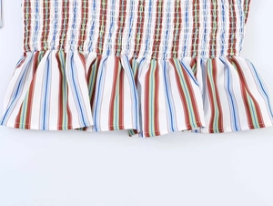 Close-up of smocked bodice on colorful striped summer top with ruffled details