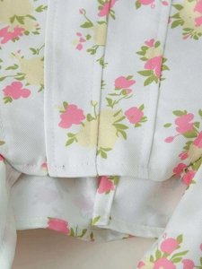 Detail shot of the floral twill fabric and premium stitching on this white two-piece set
