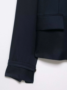 Close-up of navy blue twill fabric detail with sleeve strap and flap pocket craftsmanship
