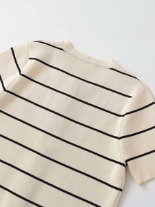 Vista dettagliata del top in maglia a righe con scollo rotondo classico e bottoni oro