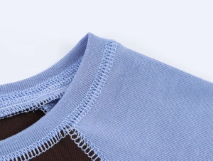 Detail of blue ribbed neckline and brown knit fabric with precise flat-lock stitching