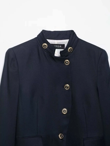 Detail of navy blue blazer featuring twill fabric and gold embossed crest buttons