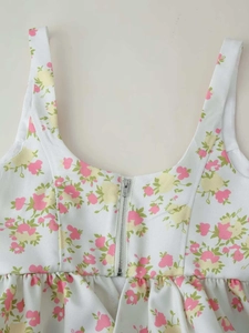 Detailed view of floral wide-leg suit with silver front zipper and woven fabric texture