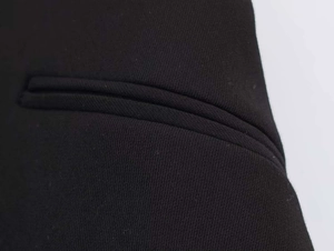 Detail shot of the welt pocket stitching and textured black fabric on this formal blazer