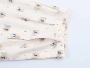 Detailed macro view of the floral print shirt cuff with a white button and fine stitching