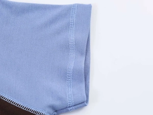 Close-up of blue ribbed knit fabric showing detailed stitching and fine texture