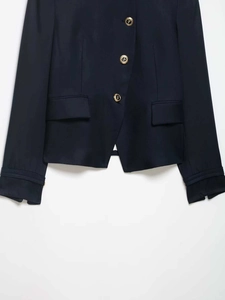Detail of navy slim fit blazer featuring decorative gold buttons and flap pockets