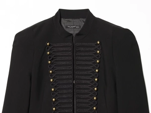 Detailed view of golden semi-circular metal buttons and black braid frog fasteners