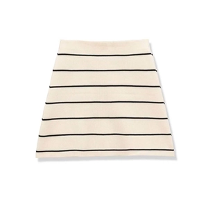 Dettaglio di una gonna svasata in maglia beige a righe nere con design a trapezio