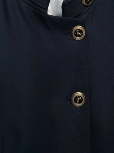 Detailed macro view of navy twill fabric and vintage gold-rimmed heraldic coat of arms button
