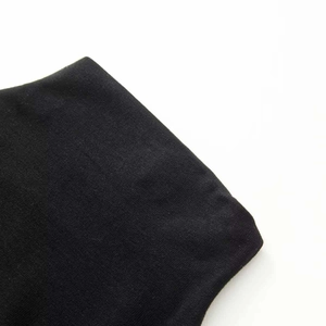 Close-up of minimalist black knitted dress fabric showing elastic texture and soft weave