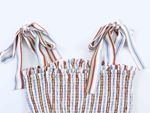 Detailed close-up of striped camisole top with shirred texture and bow straps