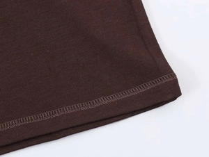 Close-up of the double-needle hem stitching on dark brown knit raglan sleeve t-shirt